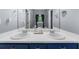 A bathroom features double sinks with modern fixtures and blue cabinets for a sleek and functional design at 5640 Rolling Oaks Dr, Cumming, GA 30040