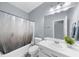 Bright bathroom featuring a shower-tub combo, white vanity with sink, and a large mirror with modern lighting at 5640 Rolling Oaks Dr, Cumming, GA 30040