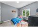 A cozy bedroom features a twin bed, large window, and playful decor, creating a comfortable and inviting space at 5640 Rolling Oaks Dr, Cumming, GA 30040