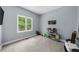 A bright bedroom with a large window overlooking lush greenery features neutral carpeting and light gray walls at 5640 Rolling Oaks Dr, Cumming, GA 30040