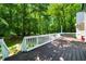 Wooden deck with white railings, overlooking a green, lush backyard, perfect for entertaining at 5640 Rolling Oaks Dr, Cumming, GA 30040