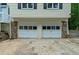 Two car garage with stone accents and the siding of the house above, offering ample parking and storage at 5640 Rolling Oaks Dr, Cumming, GA 30040