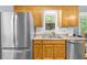 View of kitchen with stainless refrigerator, stainless dishwasher, and wood cabinets at 5640 Rolling Oaks Dr, Cumming, GA 30040