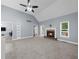 Spacious living room featuring vaulted ceilings, a fan, and a cozy fireplace at 5640 Rolling Oaks Dr, Cumming, GA 30040