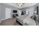 The carpeted main bedroom with a tray ceiling features soft gray walls, offering ample space and a calm atmosphere at 5640 Rolling Oaks Dr, Cumming, GA 30040