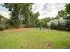 Lush backyard with mature trees, manicured lawn, and a charming fire pit area at 4645 Waterford Dr, Suwanee, GA 30024