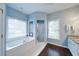 Bright bathroom featuring a soaking tub, glass shower, two windows and two different types of tile at 4645 Waterford Dr, Suwanee, GA 30024