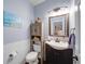 Charming powder room with stylish vanity, mirror, wainscoting, and fixtures at 4645 Waterford Dr, Suwanee, GA 30024