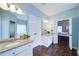 Bright bathroom featuring dual vanities, wood look floors, and an open doorway to the main bedroom at 4645 Waterford Dr, Suwanee, GA 30024