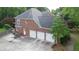 Rear exterior of brick home with three car garage and fenced yard at 4645 Waterford Dr, Suwanee, GA 30024