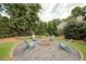 Relaxing fire pit area with Adirondack chairs surrounded by natural landscaping at 4645 Waterford Dr, Suwanee, GA 30024