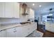 Modern kitchen features a gas cooktop, stainless steel range hood, white cabinetry, and granite counters at 4645 Waterford Dr, Suwanee, GA 30024
