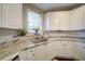 A closer view of the kitchen sink, cabinets, granite countertop, and garden window at 4645 Waterford Dr, Suwanee, GA 30024