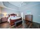 Spacious main bedroom with trey ceilings features hardwood floors, a king bed and a sitting area at 4645 Waterford Dr, Suwanee, GA 30024