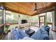 Comfortable screened porch featuring wood ceiling, ceiling fan, TV, and stylish furniture at 4645 Waterford Dr, Suwanee, GA 30024