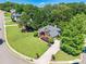 Aerial view of a beautiful home with a well-manicured lawn, lush landscaping, and a long driveway in a suburban setting at 7045 Grand View Way, Suwanee, GA 30024