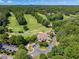 Aerial view of golf course and clubhouse with lush greenery and blue skies. Perfect for golf enthusiasts and relaxation at 7045 Grand View Way, Suwanee, GA 30024