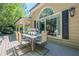 Back deck with a dining table set and a large window, offering a lovely view of the well-maintained backyard at 7045 Grand View Way, Suwanee, GA 30024