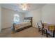 Bedroom with a small desk for convenience, with neutral carpet, fan, and window for natural light at 7045 Grand View Way, Suwanee, GA 30024