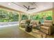 Relaxing covered deck with comfortable seating, ceiling fan, outdoor rug and views of the beautifully landscaped backyard at 7045 Grand View Way, Suwanee, GA 30024