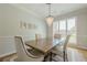 Bright dining room features a chandelier, plantation shutters and seating for four at 7045 Grand View Way, Suwanee, GA 30024