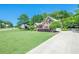 Spacious property with a large front yard, long driveway, and a well-maintained lawn and garden at 7045 Grand View Way, Suwanee, GA 30024