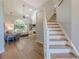 Inviting living room with hardwood floors, a staircase, and a large window overlooking the backyard at 7045 Grand View Way, Suwanee, GA 30024