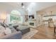 Bright living room with hardwood floors, fireplace, and a large window with views of the backyard at 7045 Grand View Way, Suwanee, GA 30024