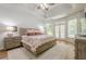 Spacious main bedroom suite featuring trey ceilings, french doors to backyard, and hardwood flooring at 7045 Grand View Way, Suwanee, GA 30024