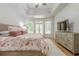 Spacious main bedroom suite featuring trey ceilings, french doors to backyard, and hardwood flooring at 7045 Grand View Way, Suwanee, GA 30024