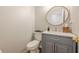 Contemporary powder room featuring a round mirror, gray vanity, and a white countertop at 7045 Grand View Way, Suwanee, GA 30024