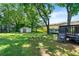 Spacious backyard with mature trees, including a deck and a storage shed at 1357 Railroad Ave, Sugar Hill, GA 30518