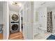 Bathroom with stacked washer dryer and shower with updated fixtures at 1357 Railroad Ave, Sugar Hill, GA 30518