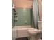 Bathroom featuring a green tiled shower-tub and low-flow toilet at 3291 Shady Oak Dr, Atlanta, GA 30340