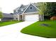 A bright home exterior featuring a well-maintained yard, white garage door, and stone accents at 3855 Saddle Bag Ct, Dacula, GA 30019