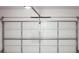 Garage door featuring square windows, and an overhead light with mechanical hardware at 3855 Saddle Bag Ct, Dacula, GA 30019