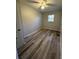 Bright bedroom with gray wood floors, a ceiling fan, and a window with views of the yard at 4510 Burks Rd, Forest Park, GA 30297
