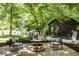 Relaxing backyard space with a stone fire pit and seating area, surrounded by lush landscaping and trees at 570 Martina Ne Dr, Atlanta, GA 30305