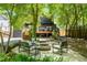 Backyard patio and firepit offer an inviting outdoor space, surrounded by lush landscaping at 570 Martina Ne Dr, Atlanta, GA 30305