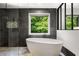 Modern bathroom featuring a freestanding tub, stylish tile work, and lots of natural light at 570 Martina Ne Dr, Atlanta, GA 30305