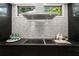 Close-up of kitchen cooktop with modern backsplash and stainless steel vent hood at 570 Martina Ne Dr, Atlanta, GA 30305