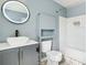 Bathroom vanity featuring basin sink, round mirror and cabinet for storage and bath tub at 6887 Slate Stone Se Way # 3, Mableton, GA 30126