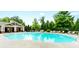 Large community pool with lounge chairs and a covered pavilion surrounded by trees at 779 Avonley Creek Trce, Sugar Hill, GA 30518