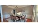 Formal dining room with decorative wainscoting, plush seating, and a contemporary chandelier at 779 Avonley Creek Trce, Sugar Hill, GA 30518
