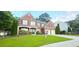Charming two-story brick home with a manicured lawn and well-maintained landscaping at 779 Avonley Creek Trce, Sugar Hill, GA 30518