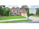 Traditional two-story brick home with well-kept lawn and a two-car garage at 779 Avonley Creek Trce, Sugar Hill, GA 30518
