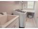 Bright laundry room with modern appliances, utility sink, and counter space for folding clothes at 779 Avonley Creek Trce, Sugar Hill, GA 30518