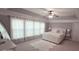Bright main bedroom featuring a plush bed, carpet flooring, and large windows at 779 Avonley Creek Trce, Sugar Hill, GA 30518