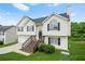 Charming two-story home featuring a black roof, light siding, and a welcoming staircase leading to the front door at 11072 Pebble Ridge Dr, Hampton, GA 30228