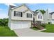Well-maintained two-story home with light siding, dark roof, and a two-car garage, complemented by lush green lawn and landscaping at 11072 Pebble Ridge Dr, Hampton, GA 30228
